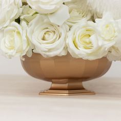 white flowers in a gold vase on a table