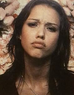 a close up of a person with flowers in the background