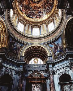 the inside of an old church with ornate paintings on the walls and ceiling, along with stained glass windows