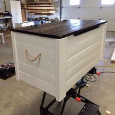 a large white box sitting on top of a black dolly in a room filled with tools