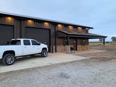 a white truck parked in front of a building with two large garage doors on it's sides