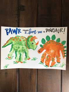 two dinosaurs painted on paper with the words rawr and i love you in dinosaur