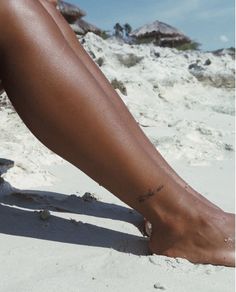 a woman's bare legs and feet on the beach