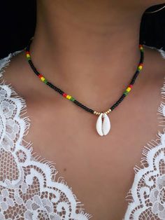 Rasta Jewelry - Rasta Bead Choker - Cowrie Shell Choker - Seashell Choker - Seashell Jewelry -  Ethiopian Jewelry - Ethiopian Necklace - African Jewelry - Rasta Necklace - Beach Choker - Cowrie Necklace - Boho Bead Choker  * D E T A I L S * This necklace is made with (1) Cowrie Shell, and Seed Beads that are strung onto durable Stretch Cord Size of Shell: between 13x9mm to 24x18mm  * S I Z E * This choker is available in the following sizes: 12 inches 12.5 inches 13 inches 13.5 inches 14 inches African Shell Necklace, Cowrie Shell Beaded Necklace, Cowrie Shell Jewelry Necklaces, Jamaica Jewelry, Rasta Necklace, Cowrie Jewelry, Seashell Choker, Seashell Jewelry Diy, African Beaded Necklace