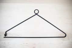 a black metal hanger on a wooden surface