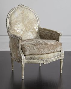 an antique style chair sitting on top of a hard wood floor next to a white wall