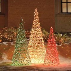 lighted christmas trees in front of a building