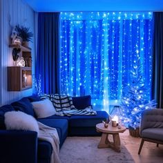 a living room filled with furniture and a christmas tree in front of a blue curtain