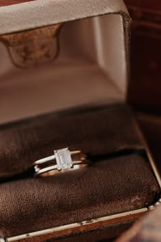 an engagement ring in a box on top of a table