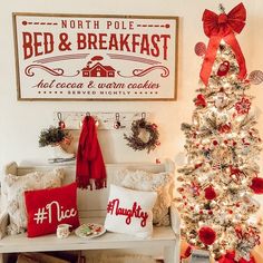 a decorated christmas tree in front of a bed and breakfast sign on the wall next to a bench