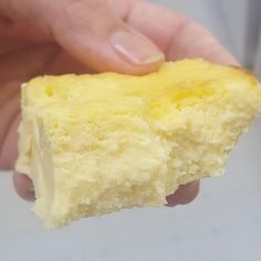 a hand holding a piece of food in it's right hand and the other half is yellow