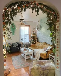 a living room filled with furniture and christmas decorations on the wall behind an arched doorway