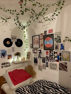 a bedroom with white walls and lots of pictures on the wall, including a tree