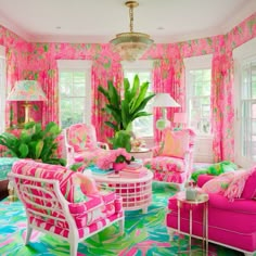 a living room filled with pink furniture and lots of green leaves on the wallpaper