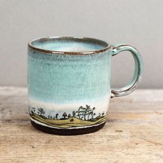 a blue and white coffee cup sitting on top of a wooden table