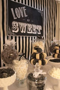 an assortment of desserts on display at a candy bar with love is sweet sign in the background