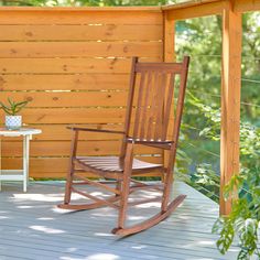 a wooden rocking chair sitting on top of a porch