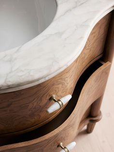 a bathroom vanity with marble top and wooden drawers