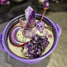 a purple cup filled with crystals on top of a table