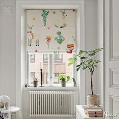 a room with a radiator, window and plants in it