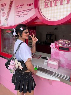 a woman standing in front of a pink kiosk