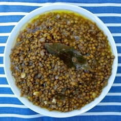 a white bowl filled with lentils on top of a blue and white table cloth