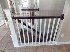 a white stair rail in a house with tile flooring