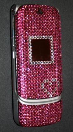 a pink cell phone covered in lots of swarongs on it's side