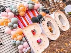 balloons and letters are arranged on the side of a building for an outdoor birthday party