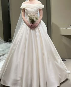 a woman in a white wedding dress holding a bouquet