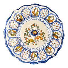 a blue and white plate with an orange flower design on the center, sitting in front of a white background