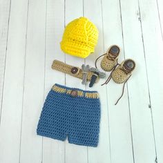 a crocheted hat, shorts and shoes are laid out on a white wooden floor