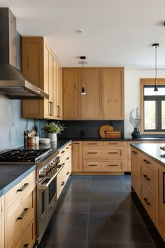 a kitchen with wooden cabinets and black counter tops