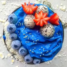 a cake with blue frosting and fruit on top