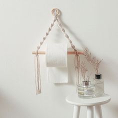 a white table topped with two bottles and a roll of toilet paper next to a towel rack