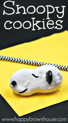 a white dog cookie sitting on top of a yellow envelope with the words snoopy cookies