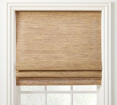 a tan roman blind in front of a window