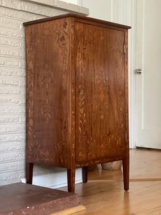 a wooden cabinet sitting on top of a hard wood floor