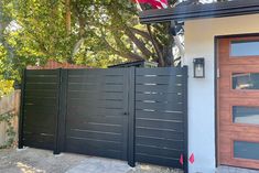 an american flag is hanging on the side of a house next to a driveway gate