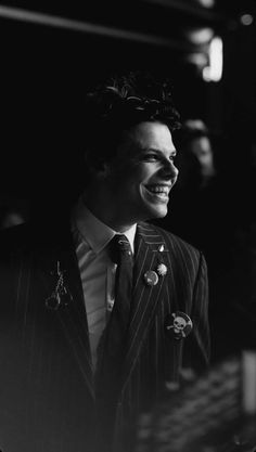 a black and white photo of a man in a pinstripe suit smiling at the camera