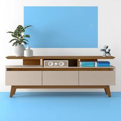 an entertainment center with books, speakers and a potted plant on it's stand