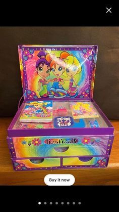 a toy chest with two girls on the front and one girl on the back in rainbow colors