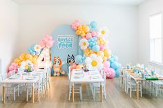 a room filled with tables and chairs covered in balloons