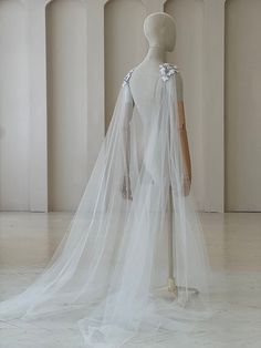 a mannequin wearing a white wedding dress with a veil on it's head