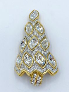 Signed gold-tone Swarovski 1996 Christmas Tree pin with original box. Red enamel back. Something Swarovski did on their better pieces, and swan signature.  This piece is featured in four books. Kathy Flood, Christmas Tree Pins on pg 270. Mary Morrison's Christmas Jewelry, pg 70. Jill Gallina, Christmas Pins 2nd Edition, and  Nancy Trowbridge, Christmas Tree Pins. Measures - 2 1/4 x 1 1/4 inches, 5.71 x 3.18 cm CONDITION: Box is shopworn, but pin in gorgeous, glittery condition. If you like what you see here stayed tune for many more Swarovski Christmas tree pins. Yellow Gold Multi-stone Brooches As Gift, Swarovski Christmas Tree, Gold Holiday Brooch Jewelry, Gold Clip-on Costume Jewelry Brooch, Swarovski Christmas, Vintage Swarovski Christmas Tree Brooch, Book Pieces, Vintage Gold Multi-stone Brooches, Christmas Pins