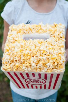 a person holding a box filled with popcorn