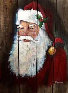 a painting of santa claus on a wooden fence