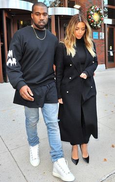 the man and woman are walking down the street together, one is wearing a black coat