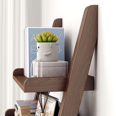 a book shelf with books and a plant on it in front of a white wall