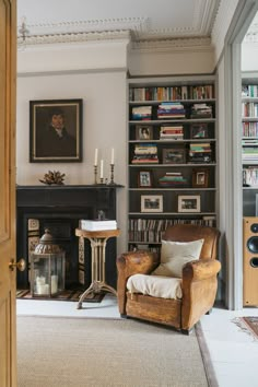 a living room filled with furniture and a fire place in front of a book shelf